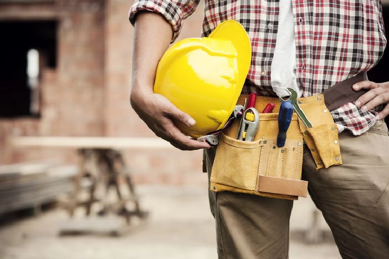 Pracownik budowy trzymający żółty kask
